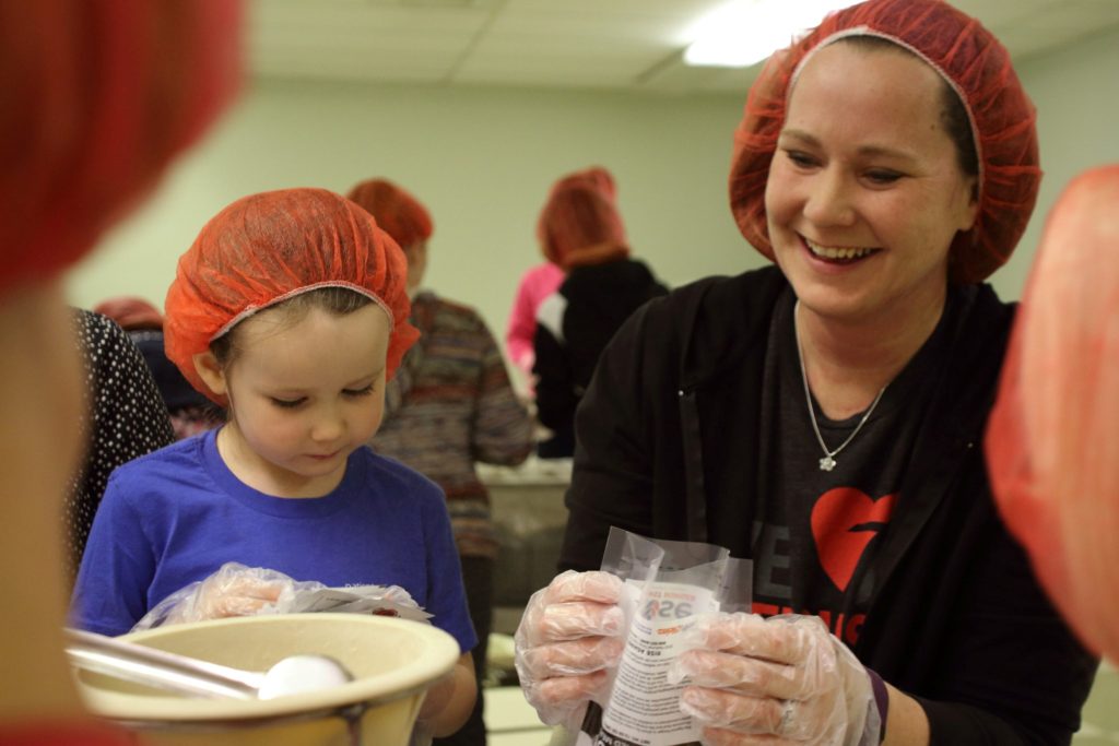 children working with a food program to provide meals to needy families